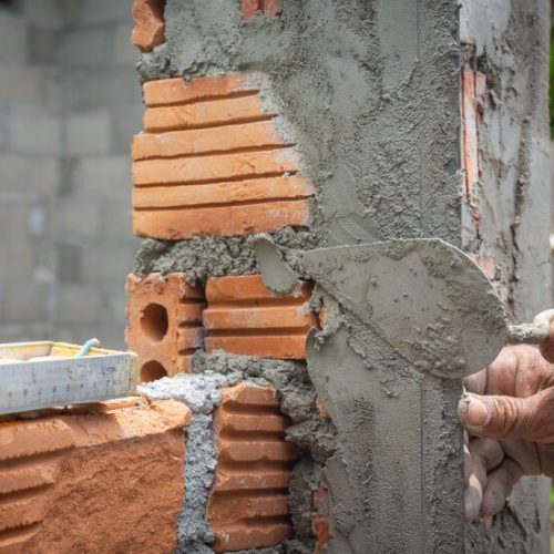 bricklaying-construction-worker-building-brick-wall_1150-14760