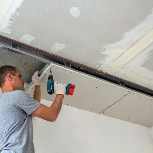 construction-worker-assemble-suspended-ceiling-with-drywall-with-screwdriver_127089-8961